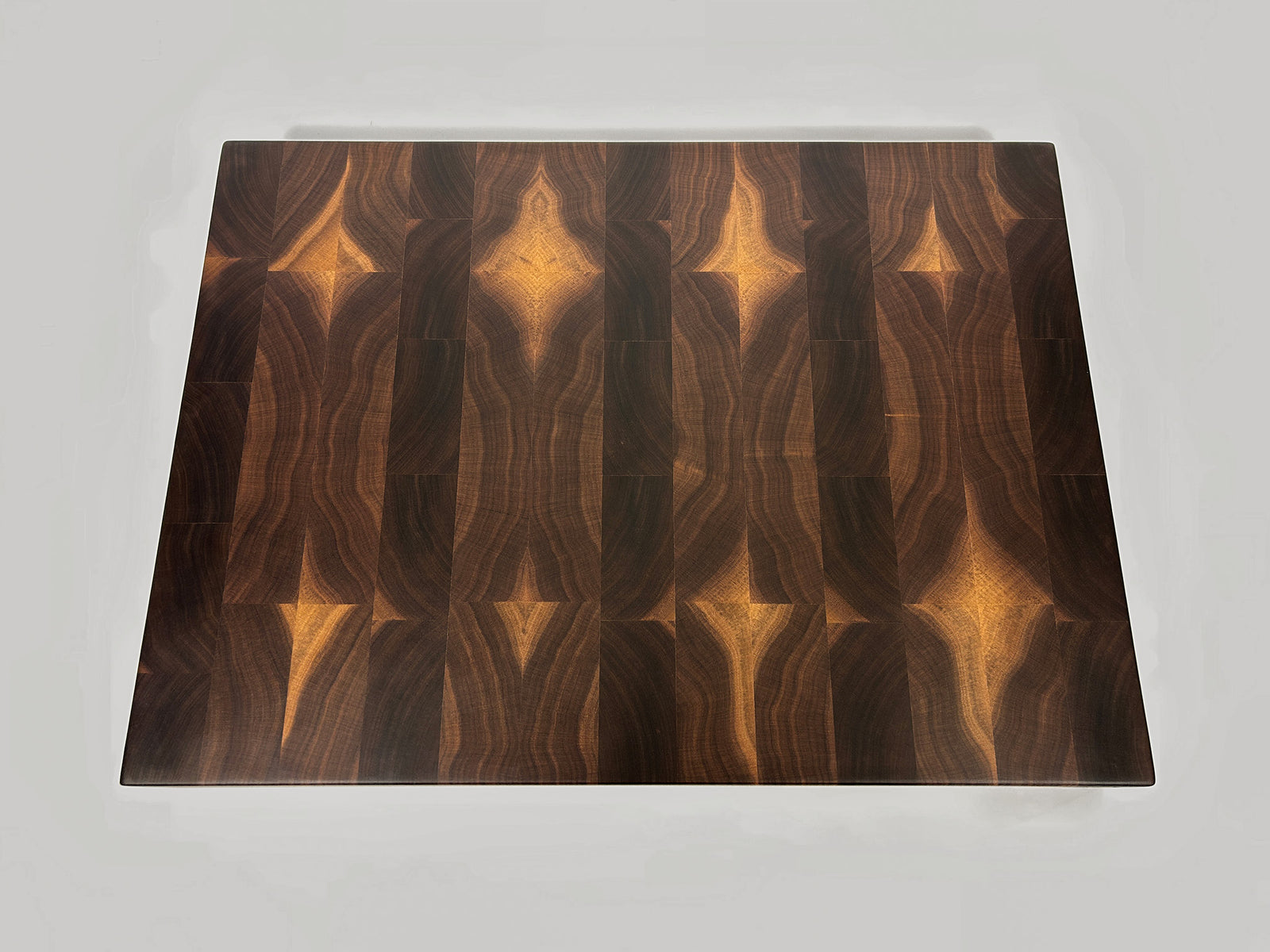 Thick End grain walnut cutting board with geometric heartwood and sapwood patterning top down view on a white background