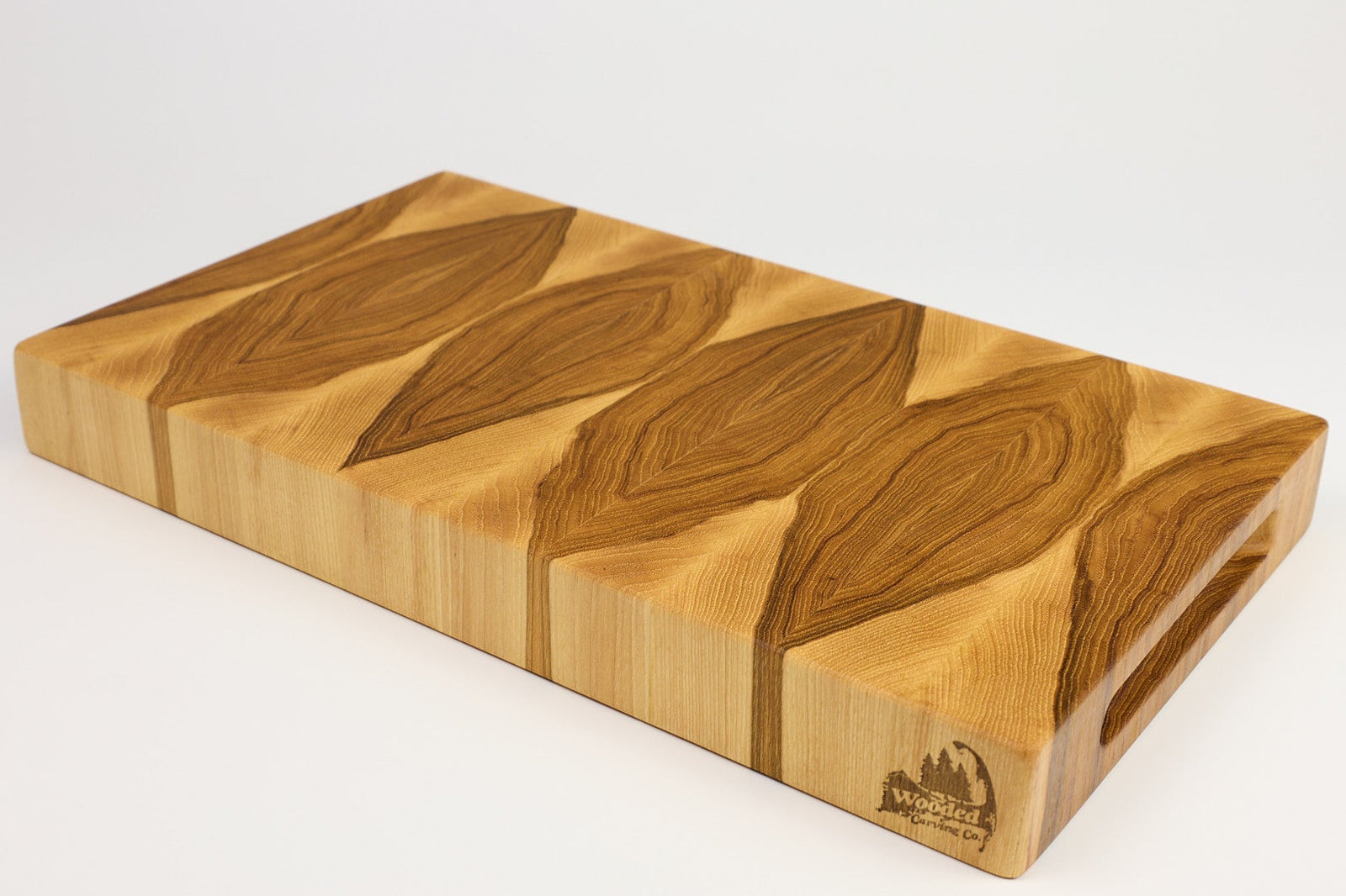 Wooden cutting board with leaf patterns on a white background