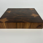 Thick walnut end-grain cutting board side view on white background with Wooded Carving Co. logo