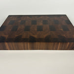 Thick, Walnut end grain cutting board with a visible brand logo on a white background