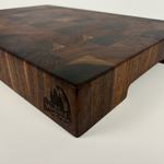 Thick, Walnut end grain cutting board with a visible brand logo on a white background