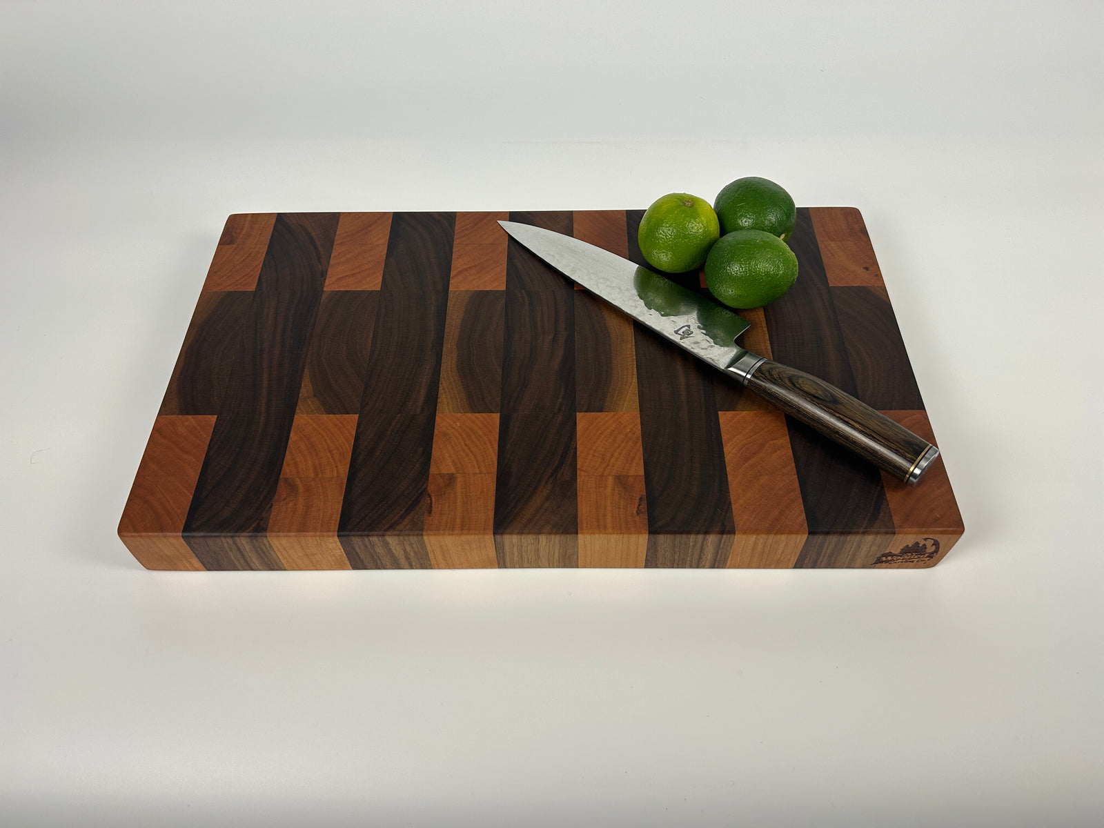 End grain Walnut and Cherry cutting board with a striped pattern on a white background