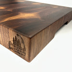 Thick End grain walnut cutting board with geometric heartwood and sapwood patterning corner view on a white background