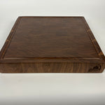 Walnut cutting board with a visible brand logo on a white background