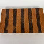 Wooden cutting board with a striped pattern on a white background