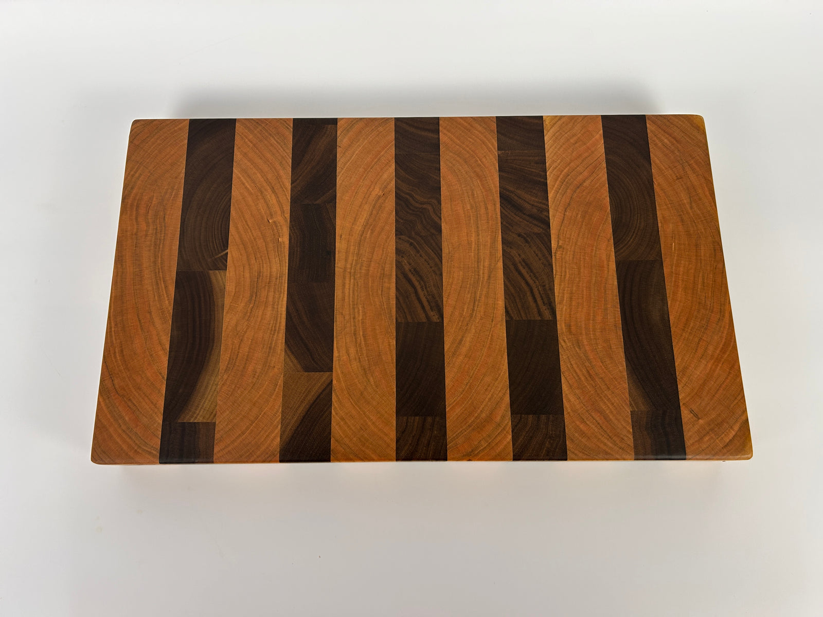 Wooden cutting board with striped pattern on a white background