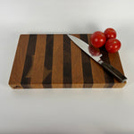 Wooden cutting board with a knife and tomatoes on a white background