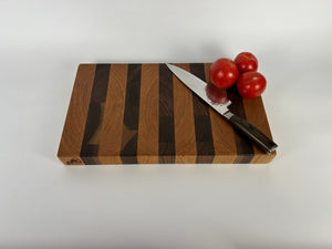 Wooden cutting board with a knife and tomatoes on a white background