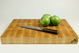 Wooden cutting board with a knife and three green apples on a white background