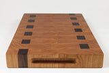 Wooden cutting board with black square patterns on a white background