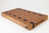 Wooden cutting board with black square holes on a white background