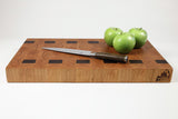 Wooden cutting board with a knife and apples on a white background