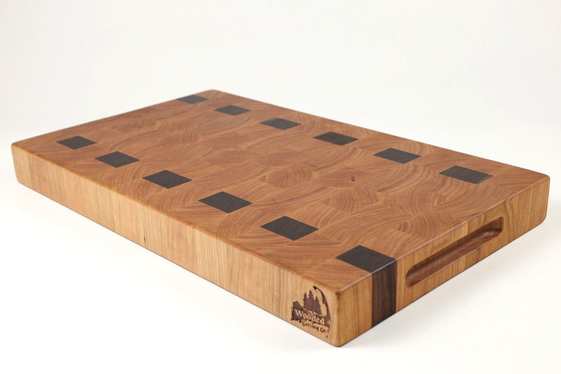 Wooden cutting board with black square holes on a white background