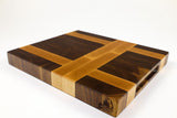 Mid-angle hero shot of The Crossroads — Walnut and Maple end-grain cutting board, 13″ × 15″ × 1.75″