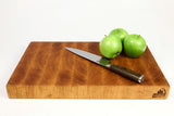 Side mid-angle of BoardCherry14 with knife and fruit for scale