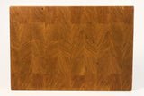Wooden cutting board with a wavy grain pattern on a white background