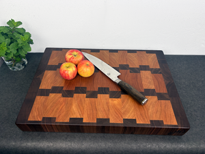 Wooden cutting board with apples and a knife on a dark surface
